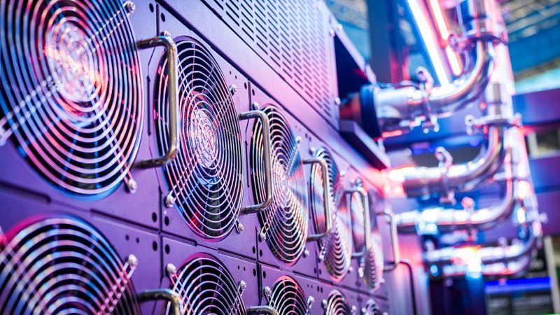 Close-up of rows of server cooling fans next to coolant pipes